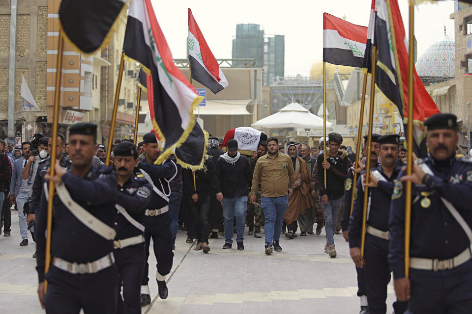 Mourners and militia fighters carry the flag-draped coffins of two fighters of the Popular Mobilization Forces who were killed during the US attack on against militants in Iraq, during their funeral procession at the Imam Ali shrine in Najaf, Iraq, Saturday, March 14, 2020. The U.S. launched airstrikes on Thursday in Iraq, targeting the Iranian-backed Shiite militia members believed responsible for a rocket attack that killed and wounded American and British troops at a base north of Baghdad. (AP Photo/Anmar Khalil)