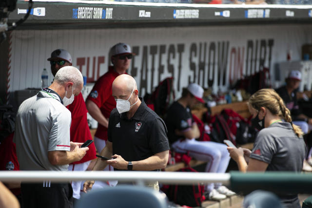 North Carolina State personnel chat in the dugout during a delay due to COVID-19 safety protocols before their baseball game against Vanderbilt in the College World Series Friday, June 25, 2021, at TD Ameritrade Park in Omaha, Neb. (AP Photo/Rebecca S. Gratz)
