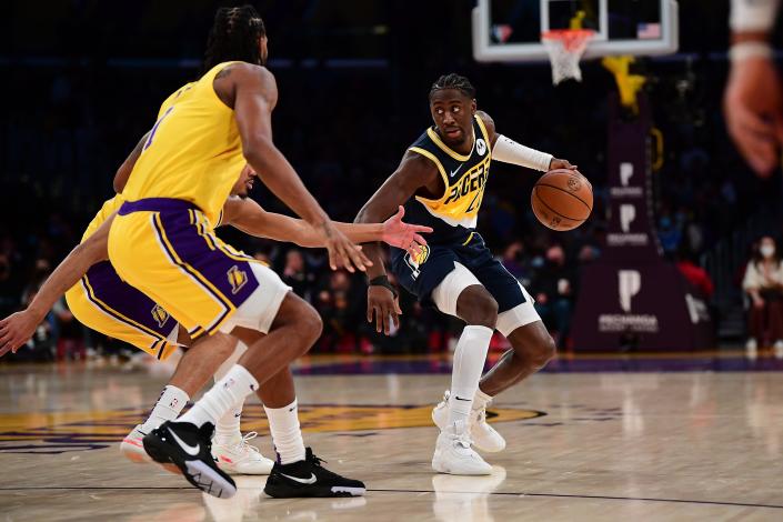 Jan 19, 2022; Los Angeles, California, USA; Indiana Pacers guard Caris LeVert (22) moves the ball against Los Angeles Lakers guard Avery Bradley (20) and forward Trevor Ariza (1) during the first half at Crypto.com Arena. Mandatory Credit: Gary A. Vasquez-USA TODAY Sports