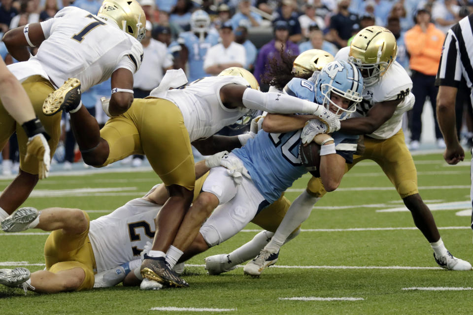 North Carolina North Carolina quarterback Drake Maye (10) is tackled by Notre Dame defensive lineman Isaiah Foskey (7), defensive lineman Justin Ademilola, middle, linebacker JD Bertrand, bottom, and cornerback TaRiq Bracy, right, during the second half of an NCAA college football game in Chapel Hill, N.C., Saturday, Sept. 24, 2022. (AP Photo/Chris Seward)