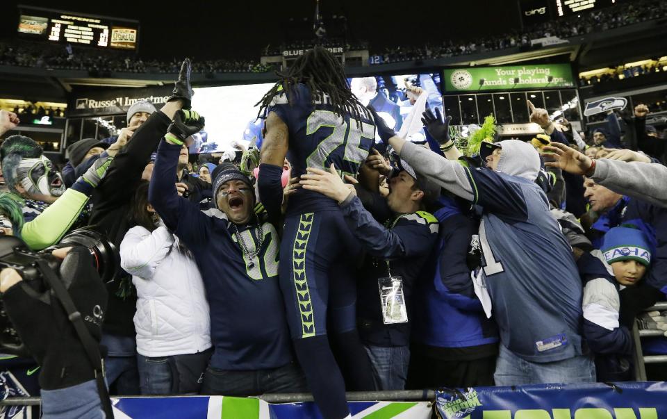 Seattle Seahawks' Richard Sherman celebrates with fans after after the NFL football NFC Championship game against the San Francisco 49ers Sunday, Jan. 19, 2014, in Seattle. The Seahawks won 23-17 to advance to Super Bowl XLVIII. (AP Photo/Elaine Thompson)