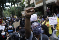 People protest against crimes committed by the police against black people in the favelas, outside the Rio de Janeiro's state government, Brazil, Sunday, May 31, 2020. The protest, called "Black lives matter," was interrupted when police used tear gas to disperse people. "I can't breathe", said some of the demonstrators, alluding to the George Floyd's death. (AP Photo/Silvia Izquierdo)