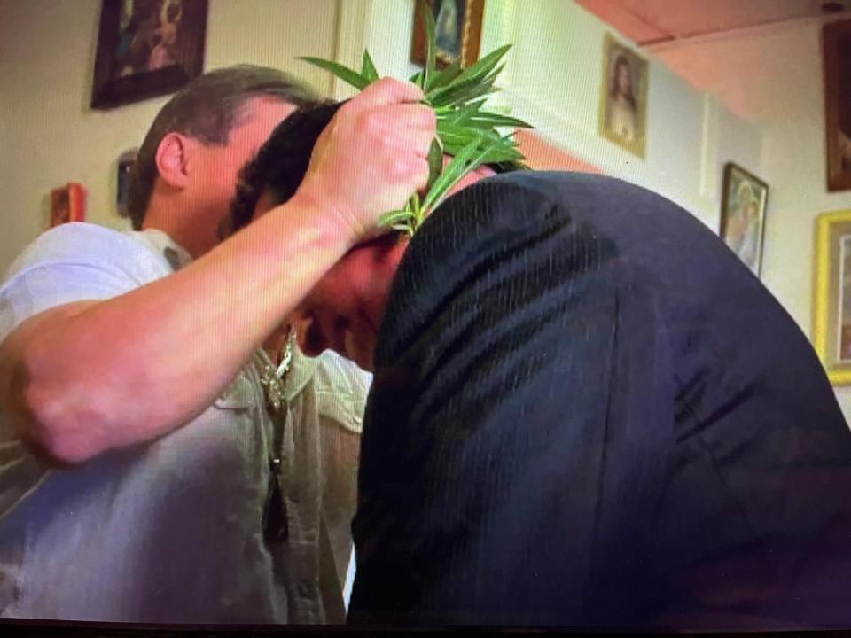 A 'brujo,' Spanish for male witch, uses branches to perform a cleansing in Mexico for Robert Almonte (right). Almonte, a retired U.S. lawman, who now teaches American police about Mexican cartels.