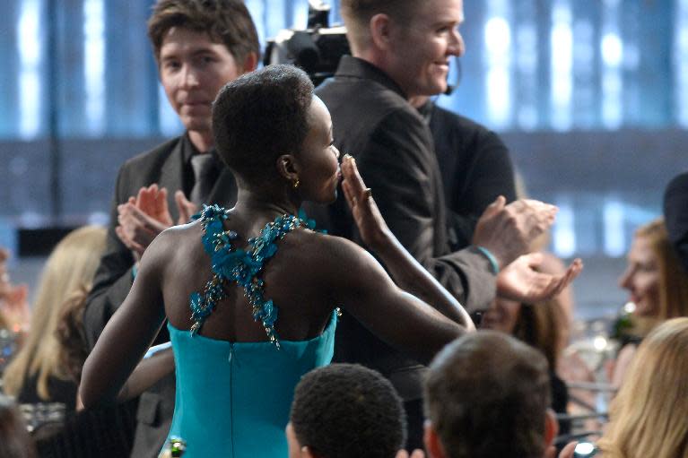 Lupita Nyong'o walks onstage to accept the Outstanding Performance by a Female Actor in a Supporting Role award for '12 Years a Slave' during the 20th Annual Screen Actors Guild Awards on January 18, 2014 in Los Angeles, California