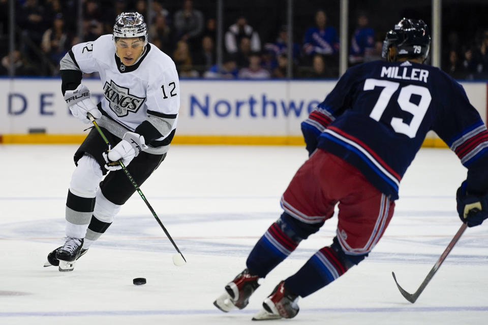 Los Angeles Kings left wing Trevor Moore (12) is defended by New York Rangers defenseman K'Andre Miller (79) during the first period of an NHL hockey game in New York, Sunday, Dec. 10, 2023. (AP Photo/Peter K. Afriyie)