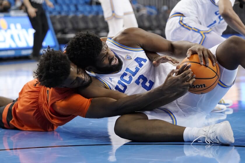 Oregon State forward Ahmad Rand, left, and UCLA forward Cody Riley go after a loose ball.