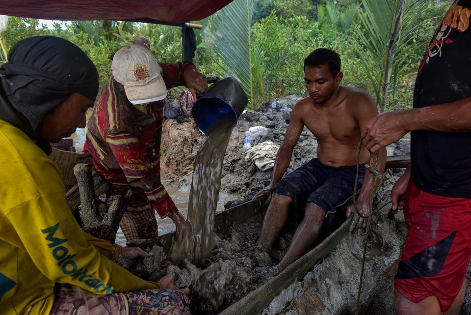 Miners washing mud with hands and feet