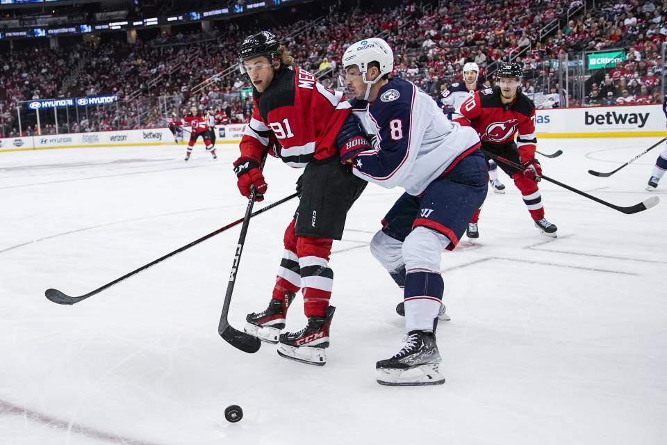 Columbus Blue Jackets defenseman Zach Werenski (8) and New Jersey Devils' Dawson Mercer (91) fight the puck during the third period of an NHL hockey game Sunday, Oct. 30, 2022, in Newark, N.J. (AP Photo/Eduardo Munoz Alvarez)