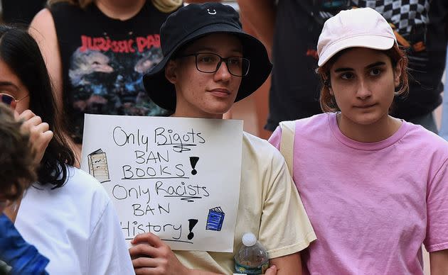 A person holds a placard at a 