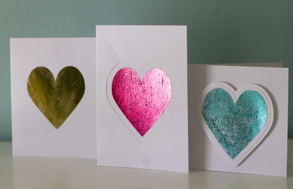 This photo taken Jan. 27, 2019 shows valentine cards made in Hopkinton, N.H. Adding foil to greeting cards can turn the simplest shape into something more fancy. These cards shown here were made by applying colored foil three different ways. The gold heart was made using double-sided adhesive, the pink heart was made using a laser printer and laminating machine and the blue heart was made using a a stencil and spray adhesive. (AP Photo/Holly Ramer)