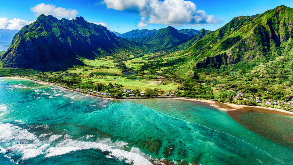 The beautiful and unique landscape of coastal Oahu, Hawaii and the Kualoa Ranch where Jurassic Park was filmed as shot from an altitude of about 1000 feet over the Pacific Ocean.