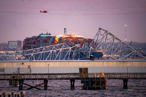 A US Coast Guard helicopter flies over the Dali container vessel after it struck the Francis Scott Key Bridge that collapsed into the Patapsco River in Baltimore, Maryland, US, on Tuesday, March 26, 2024. The commuter bridge collapsed after being rammed by the Dali ship, causing vehicles to plunge into the water. Photographer: Al Drago/Bloomberg via Getty Images