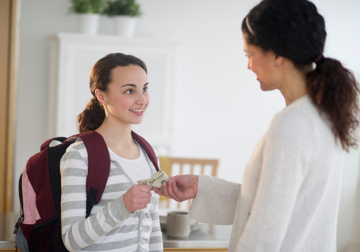 Mom gives daughter some money.