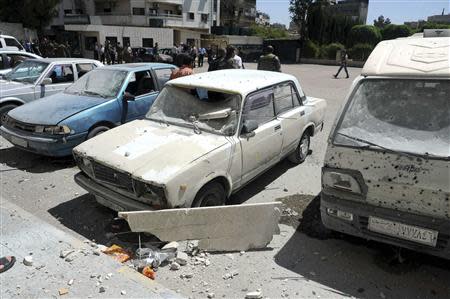 Damaged vehicles are seen after mortar bombs landed on two areas in Damascus April 29, 2014, in this handout photograph released by Syria's national news agency SANA. REUTERS/SANA/Handout via Reuters