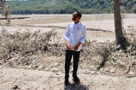 In this photo released by the Indonesian Presidential Palace, Indonesian President Joko Widodo inspects an area covered in ash from the eruption of Mount Semeru in Lumajang district, East Java province, Indonesia, Tuesday, Dec. 7, 2021. Widodo visited areas devastated by the powerful volcanic eruption that killed a number of people and left thousands homeless, and vowed that communities would be quickly rebuilt. (Indonesian Presidential Palace via AP)