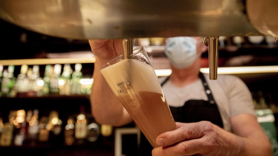 Ein Wirt mit Maske zapft in einer Kneipe im Berliner Bezirk Wilmersdorf ein Bier. Die Sperrfrist in der Bundeshauptstadt ist vor Gericht gekippt worden.