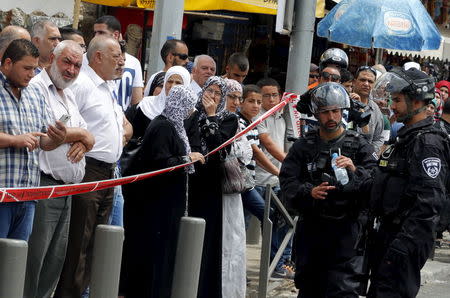 Onlookers stand at the scene of a stabbing near the Damascus Gate of Jerusalem's Old City June 21, 2015. REUTERS/Ammar Awad