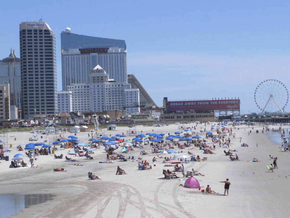 People bask in the sun at the Atlantic City, N.J., beachfront, July 9, 2018. In a move made without public announcement or debate, a state Assembly panel on Tuesday, June 27, 2023, amended a bill that would have extended New Jersey's internet gambling law for another 10 years. shortening that time frame to just two years. (AP Photo/Wayne Parry)