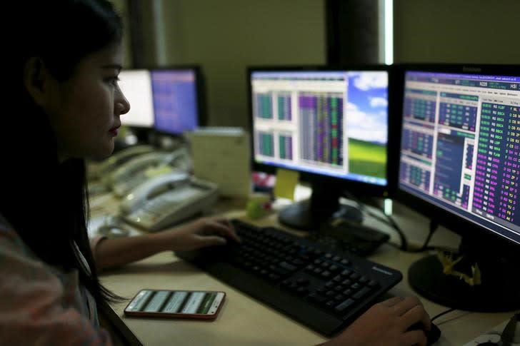 A trader monitors share prices at the Bank Mandiri Sekuritas trading floor in Jakarta August 25, 2015. REUTERS/Beawiharta/Files