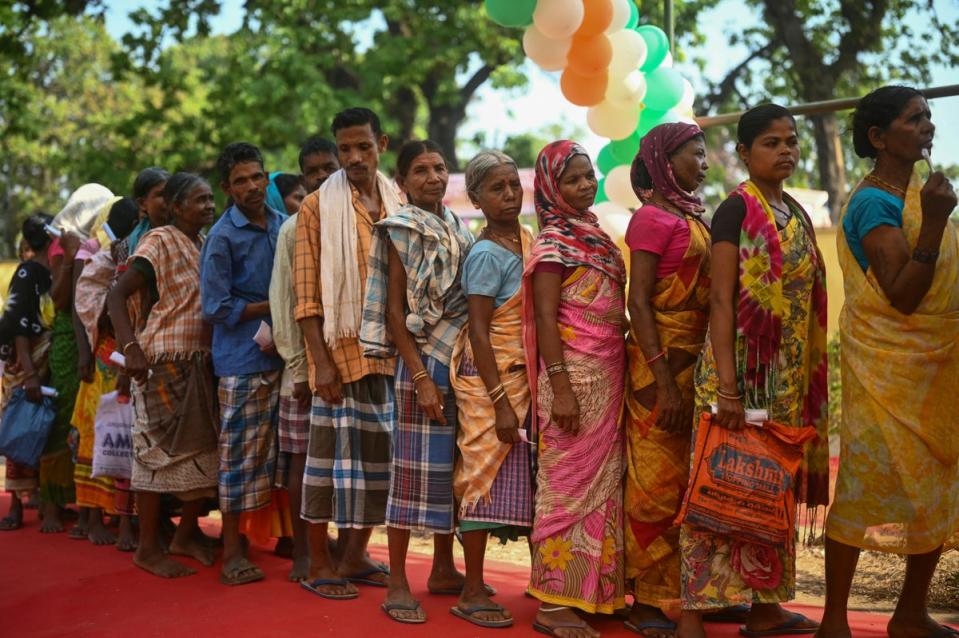 People line up outside a polling station in Dugeli village of Dantewada in central India’s Chhattisgarh state on 19 April 2024 (AFP via Getty Images)