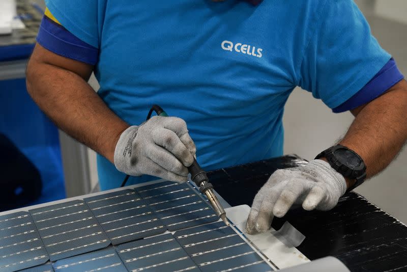 FILE PHOTO: Employees work on solar panels at the QCells solar manufacturing factory in Dalton