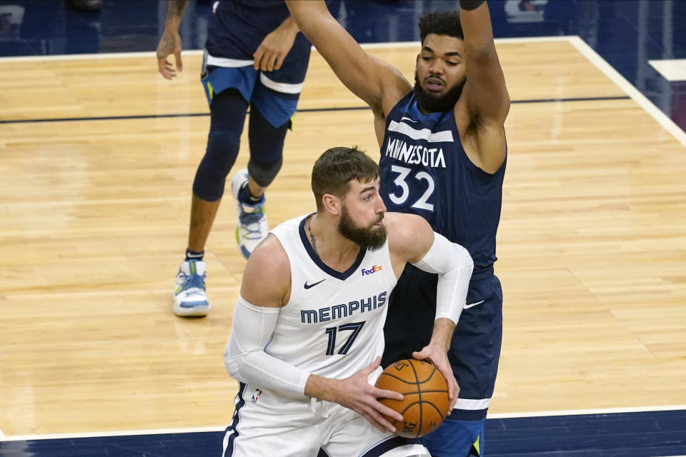 Memphis Grizzlies' Jonas Valanciunas (17) makes his way past Minnesota Timberwolves' Karl-Anthony Towns (32) in the first half of an NBA basketball game, Wednesday, Jan. 13, 2021, in Minneapolis. (AP Photo/Jim Mone)