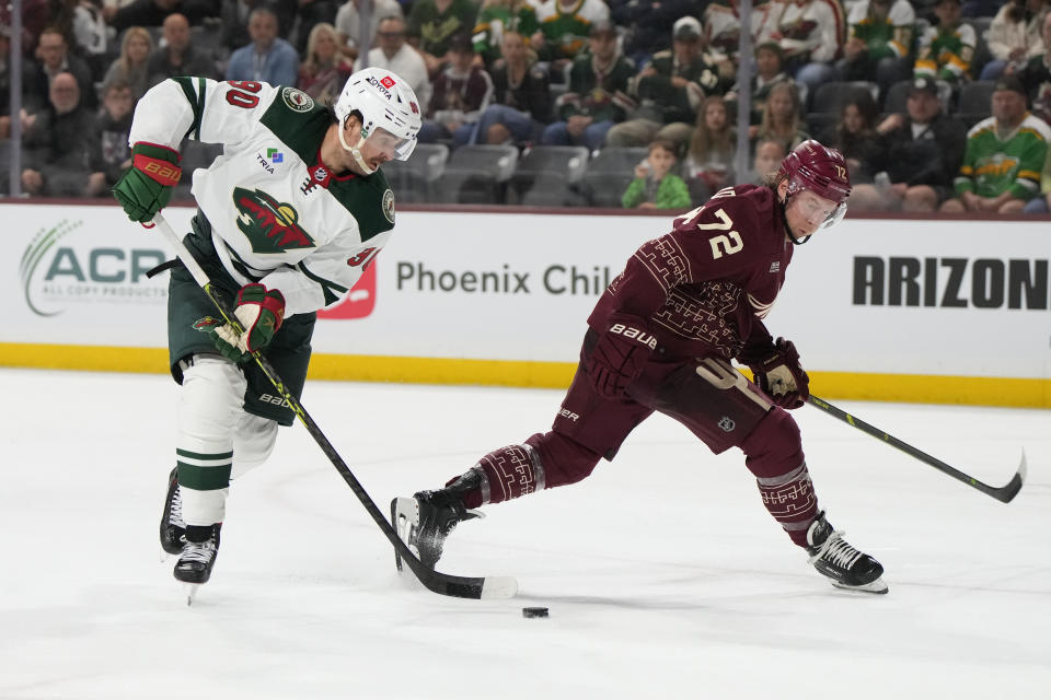 Minnesota Wild left wing Marcus Johansson skates around Arizona Coyotes center Travis Boyd (72) during the third period of an NHL hockey game, Sunday, March 12, 2023, in Tempe, Ariz. Arizona won 5-4 in overtime. (AP Photo/Rick Scuteri)