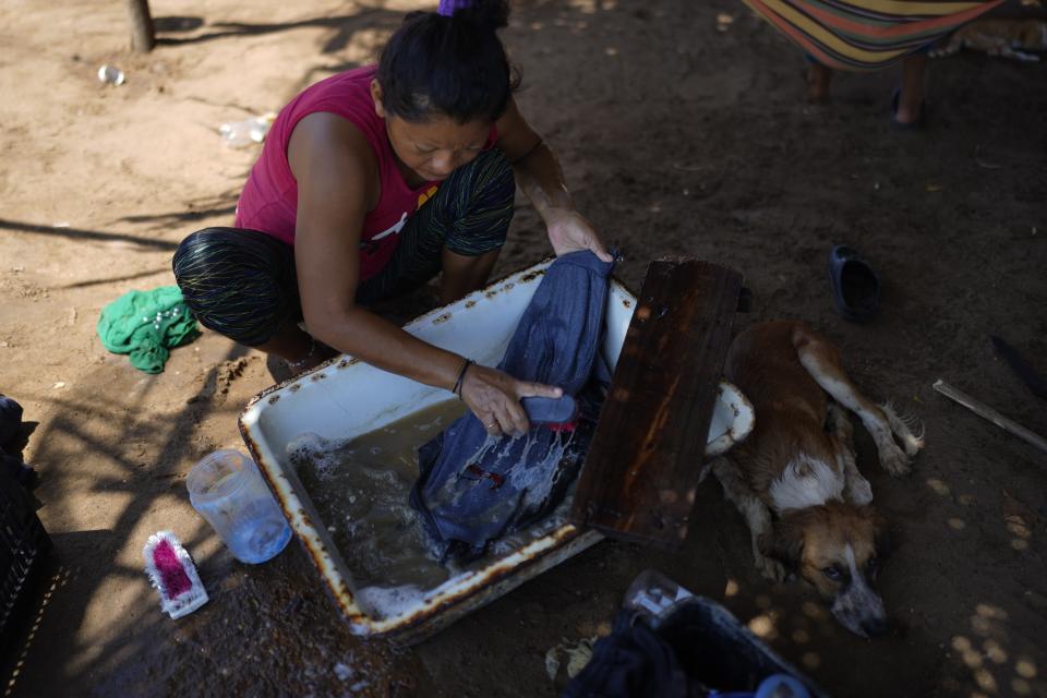 A woman hand washes her laundry with water from Lake Maracaibo in San Francisco, Venezuela, Wednesday, Aug. 9, 2023. The pollution around the lake, one of Latin America's largest, is the result of decades of excessive oil exploitation on its bed, inadequate maintenance, and a lack of investment to improve an already obsolete infrastructure, according to environmentalists. (AP Photo/Ariana Cubillos)