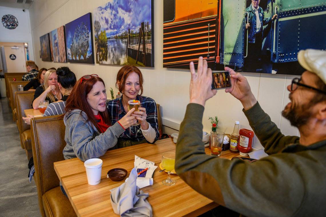 Tim Lehmann takes a picture of Amber Lehmann, left, and Keri Lehmann, right, holding a drink named “That’s Pretty,” at The Morning Fork on Monday, Sept. 30, 2019. The Lehmann’s were visiting from Dallas Texas and saw the restaurant on Yelp. “So you have a mission and a purpose for your restaurant that we love,” said Amber while talking to owner Jennifer Swiryn.