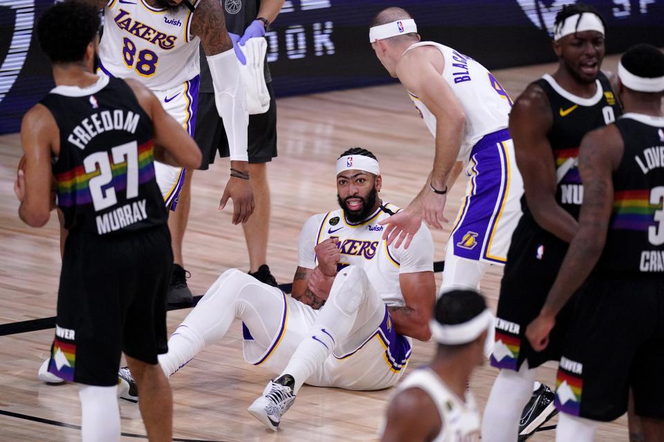 Denver Nuggets' Jamal Murray (27) looks on as Los Angeles Lakers' Anthony Davis (3) grabs his wrist after falling to the floor during play in the second half of Game 3 of the NBA basketball Western Conference final Tuesday, Sept. 22, 2020, in Lake Buena Vista, Fla. (AP Photo/Mark J. Terrill)