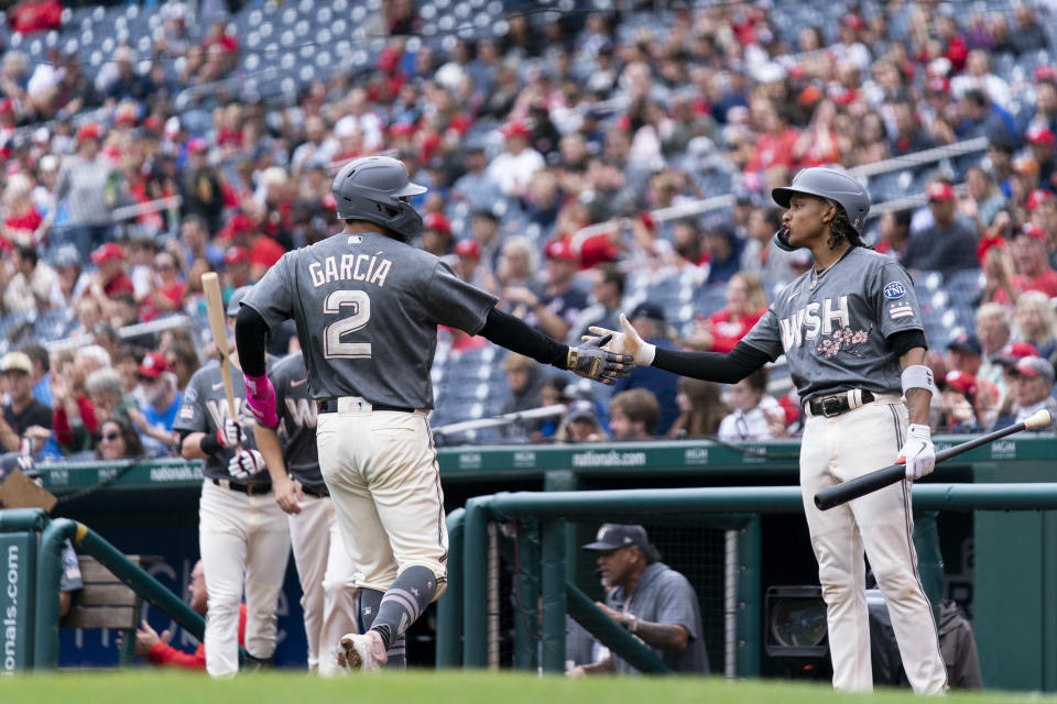 Washington Nationals' Luis Garcia, left, celebrates with teammate CJ Abrams, right, after scoring on an RBI hit in by Nationals' Jacob Young during the second inning of a baseball game against the Atlanta Braves, Sunday, Sept. 24, 2023, in Washington. (AP Photo/Stephanie Scarbrough)