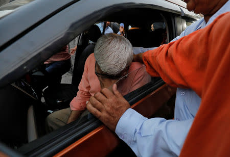 Gulshan Suneja, father of Bhavye Suneja, a pilot of Lion Air flight JT610 which crashed into the sea, is consoled before he leaves for Jakarta, in New Delhi, India. REUTERS/Anushree Fadnavis