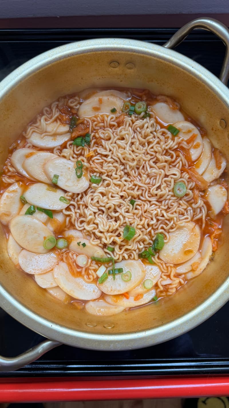 Korean rice cakes in a pot with ramen noodles.