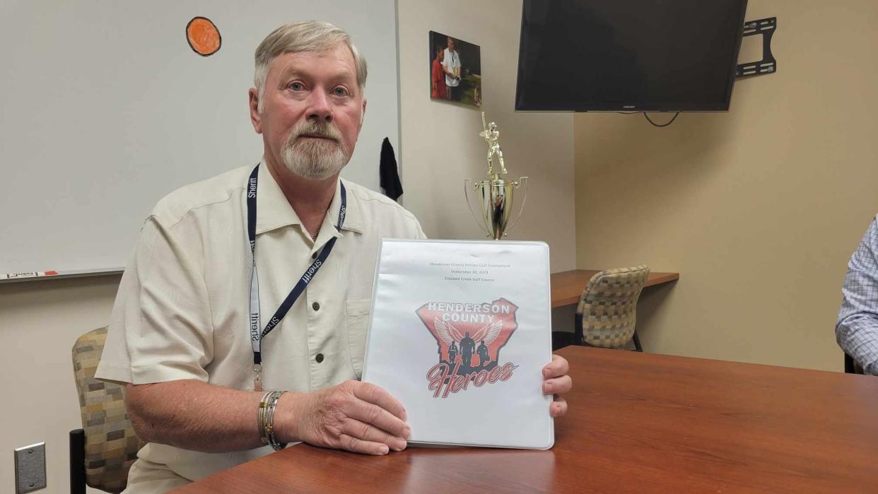 Retired Henderson County Sheriff George Erwin poses with a book containing information about the new nonprofit Henderson County Heroes at the Henderson County Sheriff's Office on Aug. 24.