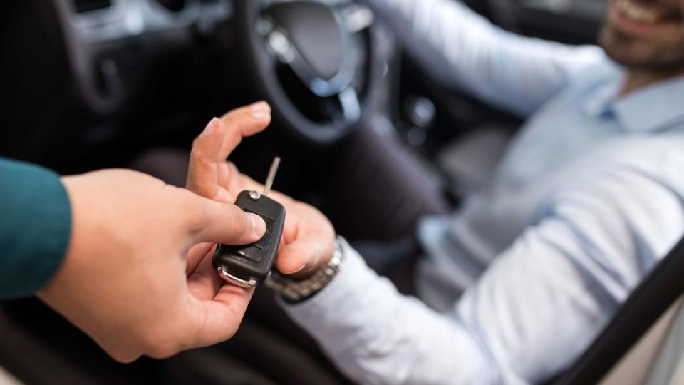 close up of a man receiving new car key