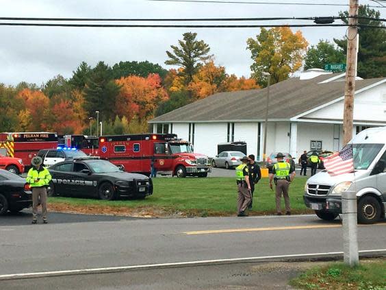 In this photo provided by WMUR-TV, police stand outside the New England Pentecostal Church after a shooting during a wedding on Saturday, 12 October 2019, in Pelham, New Hampshire. (Siobhan Lopez/WMUR-TV via AP)