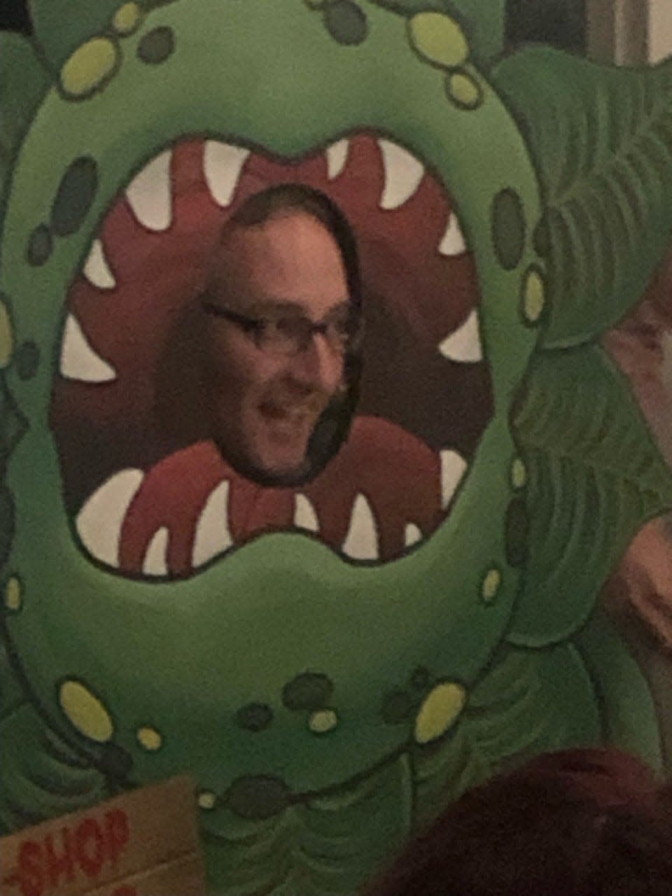 Lee Frank, director of development for the Prescott Park Arts Festival, poses in a prop that announces the festival will present "Little Shop of Horrors" at a reveal party Thursday.