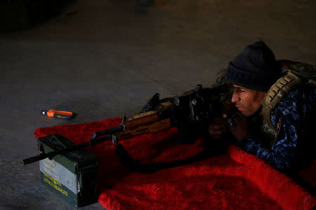 A sniper of the Iraqi Federal Police takes his position at a destroyed builiding near Islamic State fighters' positions at Bab al Jadid district in the old city of Mosul. REUTERS/Youssef Boudlal