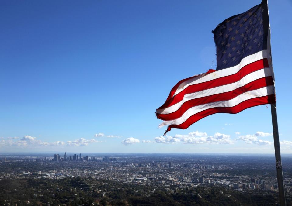 A torn United States flag overlooks Los Angeles the day after Election Day, at the end of a trail near the Wisdom Tree