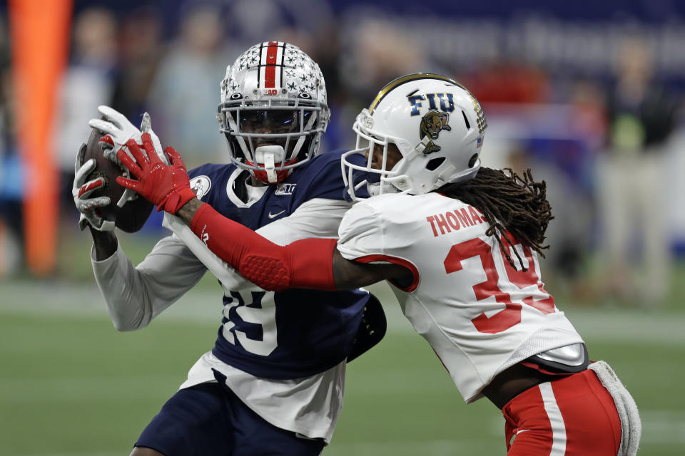 West wide receiver Binjimen Victor, of Ohio State, (19) pulls in a touchdown pass in front of East cornerback Stantley Thomas-Oliver III, of Florida International University, (39) during the second half of the East West Shrine football game Saturday, Jan. 18, 2020, in St. Petersburg, Fla. (AP Photo/Chris O'Meara)