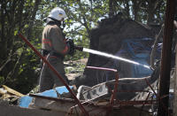 Ukrainian State Emergency Service firefighter works to extinguish a fire at at damaged residential building in the town of Serhiivka, located about 50 kilometers (31 miles) southwest of Odesa, Ukraine, Friday, July 1, 2022. Russian missile attacks on residential areas in a coastal town near the Ukrainian port city of Odesa early Friday killed at least 19 people, authorities reported, a day after Russian forces withdrew from a strategic Black Sea island. (AP Photo/Nina Lyashonok)