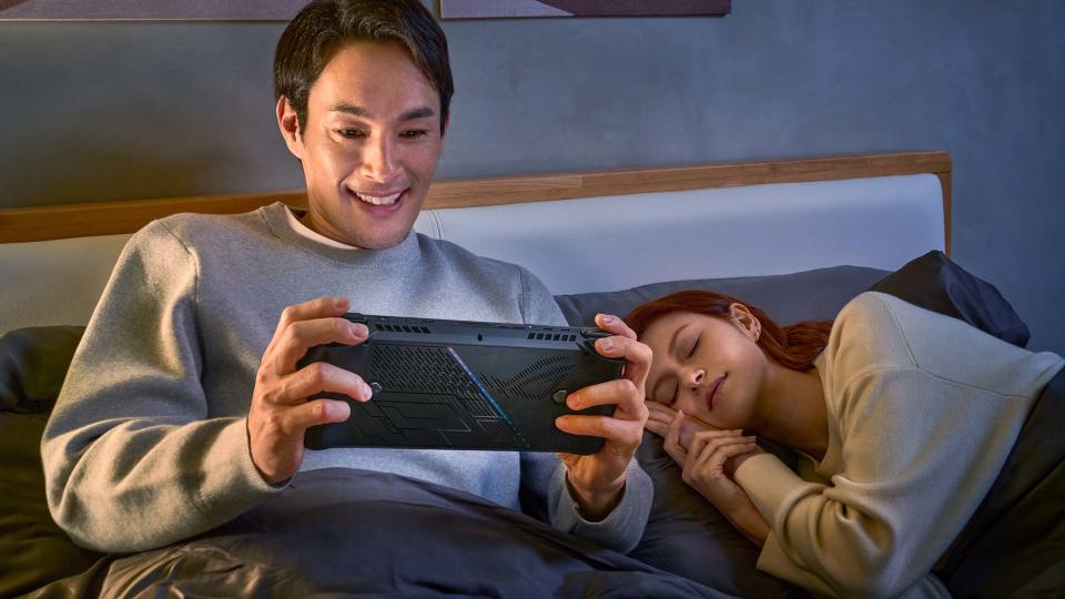 ASUS ROG Ally X being played in bed by a man.