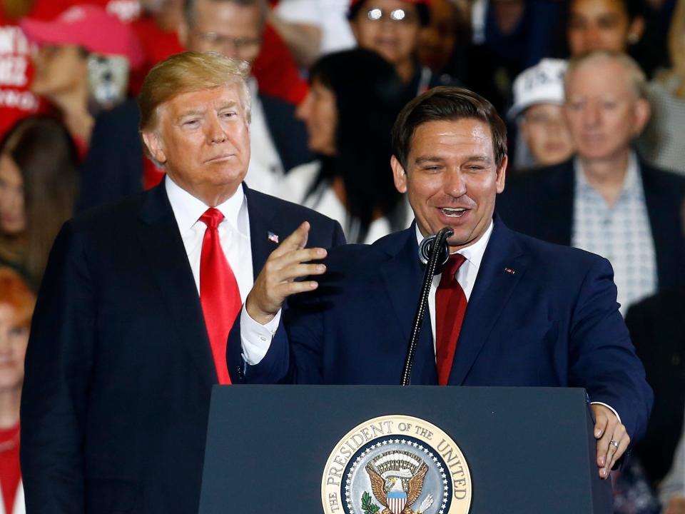 In this November 3, 2018, file photo President Donald Trump stands behind then-gubernatorial candidate Ron DeSantis at a rally in Pensacola, Florida.