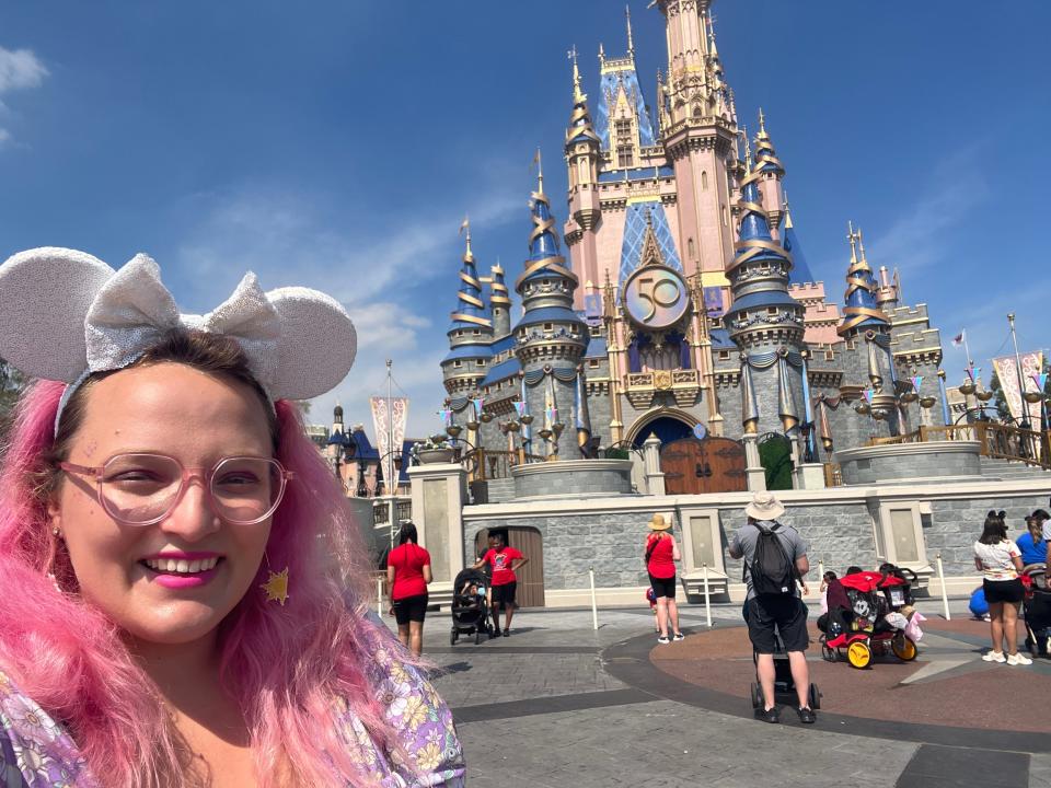 casey posing for a selfie in front of cinderella castle at magic kingdom in disney world