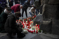 Mourners lay down candles and flowers at the Porta Nigra in Trier the morning after the amok drive with five dead people in Trier, Germany, Wednesday, Dec.3, 2020. Numerous people commemorate the victims of the amok drive of a 51-year-old man through the city centre. (Harald Tittel/dpa via AP)