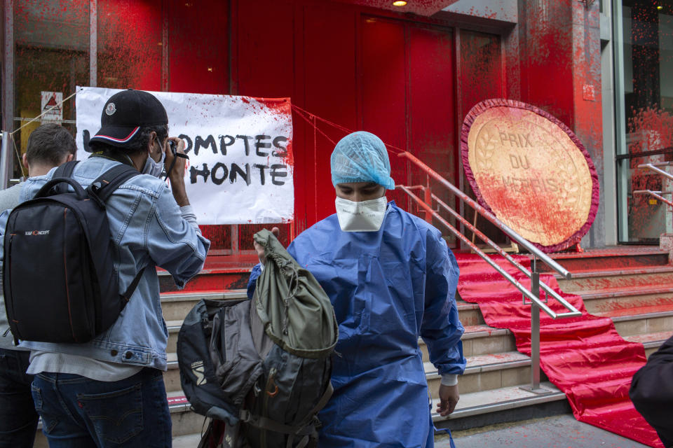 French activists of Attac stage a flash protest outside the French Health Ministry in support of medical workers, in Paris, France, Saturday, June 20, 2020. French hospital workers and others are protesting to demand better pay and more investment in France's public hospital system, which is considered among the world's best but struggled to handle a flux of virus patients after years of cost cuts. (AP Photo/Rafael Yaghobzadeh)