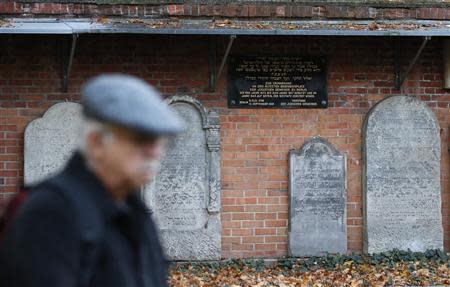 A visitor walks past gravestones at Grosse Hamburger Strasse Jewish cemetery in Berlin, October 31, 2013. REUTERS/Fabrizio Bensch