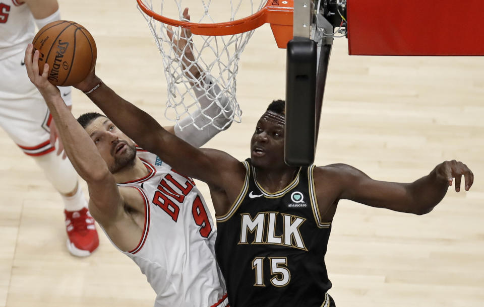 Chicago Bulls' Nikola Vucevic, left, and Atlanta Hawks' Clint Capela (15) vie for a rebound during the first half of an NBA basketball game Friday, April 9, 2021, in Atlanta. (AP Photo/Ben Margot)