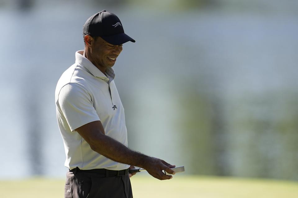 Tiger Woods looks at his putter on the 16th green during a practice round in preparation for the Masters golf tournament at Augusta National Golf Club Monday, April 8, 2024, in Augusta, Ga. (AP Photo/George Walker IV)