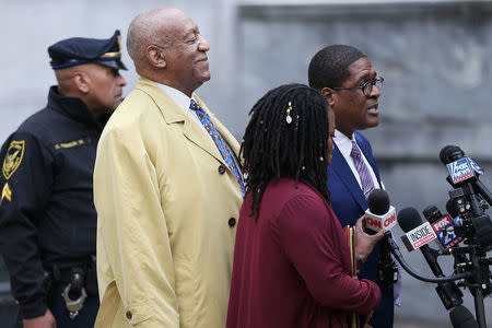 Actor and comedian, Bill Cosby, stands as his spokesman, Andrew Wyatt speaks to reporters outside the Montgomery County Courthouse during for his sexual assault retrial case in Norristown, Pennsylvania, U.S., April 24, 2018. Tim Tai/Pool via Reuters